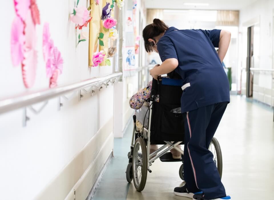 介護職員が車いすを押す様子